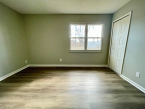 Louisville house for rent - A room with a wooden floor and a white door.