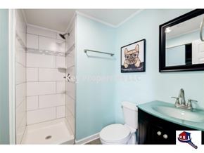 Madisonville house for rent - A bathroom with a toilet, sink, and a picture of a dog.