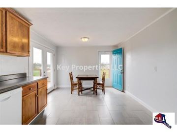 Madisonville house for rent - A kitchen with wooden cabinets and a dining table.
