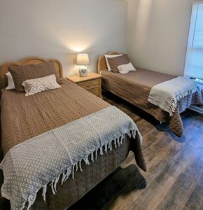 Loudon house for rent - A bedroom with two beds and a nightstand with a lamp.