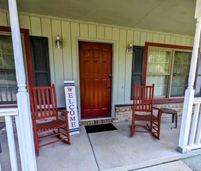 Loudon house for rent - A porch with a red door and two chairs.