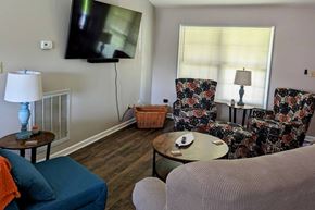Loudon house for rent - A living room with a television, two chairs, a sofa, a table, and a basket.