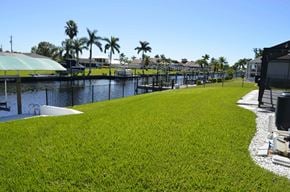 Cape Coral house for rent - A grassy area with a fence and a body of water.