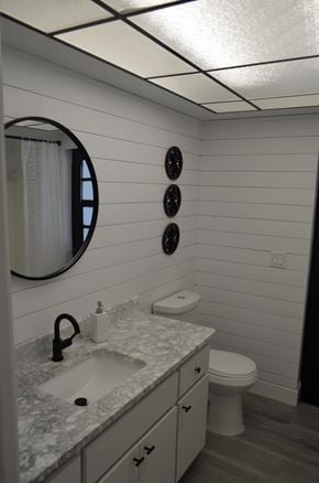 Cape Coral house for rent - A bathroom with a sink, toilet, and mirror.