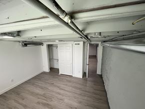 St. Louis house for rent - A room with a white door and a white wall with a pipe running along the ceiling.