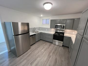 St. Louis house for rent - A kitchen with a stainless steel refrigerator, microwave, and oven.
