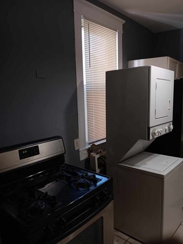 Baltimore apartment for rent - A black stove top oven sits next to a white dishwasher in a kitchen.