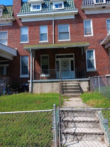 Baltimore apartment for rent - A red brick house with a white door and a small porch.