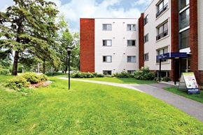 Ottawa apartment for rent - A grassy area in front of a building with a sign on the right.