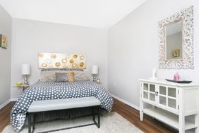 Ottawa apartment for rent - A bedroom with a bed, nightstand, and a mirror.
