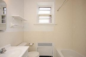 Ottawa apartment for rent - A white bathroom with a toilet, sink, and bathtub.
