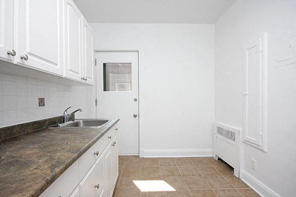 Ottawa apartment for rent - A kitchen with white cabinets and a granite countertop.