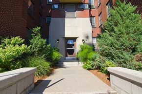 Ottawa apartment for rent - A concrete pathway leads to a building entrance.