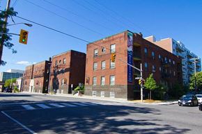 Ottawa apartment for rent - A street view of a red brick building with a traffic light on green.