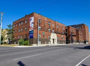 Ottawa apartment for rent - A large brick building with a blue sign on the front.
