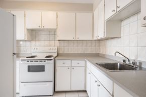 Cote St Luc apartment for rent - A white kitchen with a stove, oven, and cabinets.