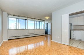Toronto apartment for rent - A large empty room with wooden floors and white walls.