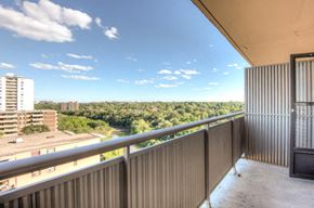 Toronto apartment for rent - A balcony overlooks a cityscape with a river and trees.