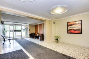Mississauga apartment for rent - A hallway with a bench, a painting, and a plant.