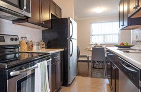 Burlington apartment for rent - A kitchen with black appliances and brown cabinets.