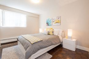 Burlington apartment for rent - A bedroom with a bed, nightstand, and a window.