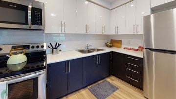 Guelph apartment for rent - A modern kitchen with dark blue cabinets and stainless steel appliances.