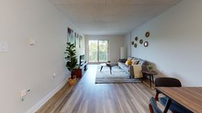 Guelph apartment for rent - A living room with a couch, chairs, and a potted plant.