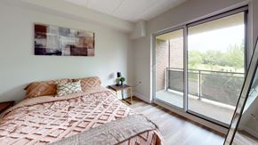 Guelph apartment for rent - A bedroom with a large bed and a painting on the wall.
