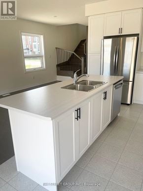 Newmarket (Woodland Hill) house for rent - A kitchen with white cabinets and a stainless steel refrigerator.
