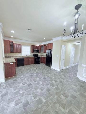 Chambersburg apartment for rent - A kitchen with a black refrigerator and a chandelier.