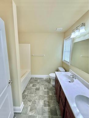 Chambersburg apartment for rent - A bathroom with a toilet, sink, and mirror.