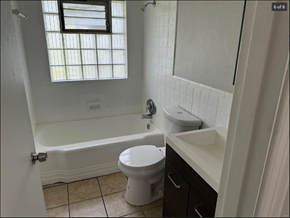 St. Louis house for rent - A white toilet sits in a bathroom next to a bathtub and sink.