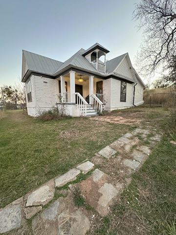 Cisco house for rent - A white house with a grey roof and a stone pathway leading to the front door.