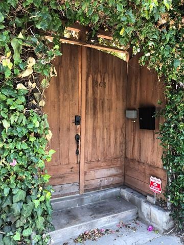 Venice Beach apartment for rent - A wooden door with a black mailbox and a red and white sign on the steps.