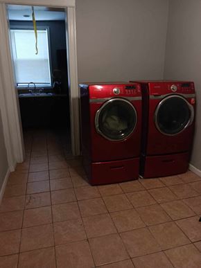 Baltimore apartment for rent - Two red washing machines in a laundry room.
