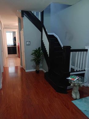 Baltimore apartment for rent - A hallway with a wooden floor and a staircase.
