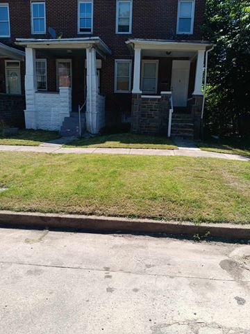 Baltimore apartment for rent - A red brick house with a white door and windows.