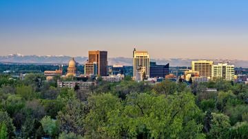 Boise apartment for rent - A cityscape with a mountain range in the background and a large building with a golden dome in the foreground.