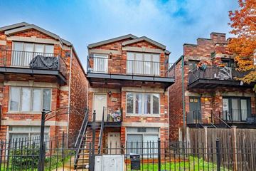 Chicago apartment for rent - A row of red brick houses with black railings and white windows.