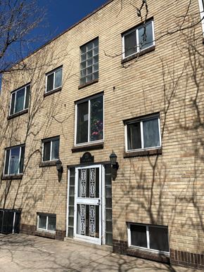 Denver apartment for rent - A large building with a red door is situated on a street.