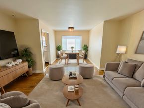 Denver apartment for rent - A living room with a grey couch, a wooden coffee table, and a large window.