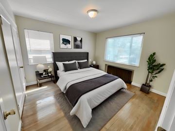 Denver apartment for rent - A bedroom with a large bed and a plant.