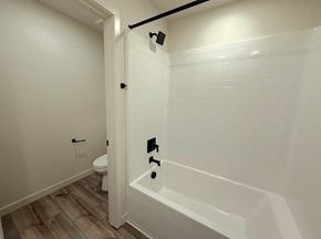 Merced house for rent - A white bathroom with a tub and toilet.