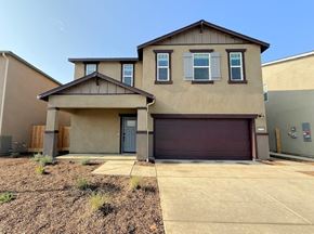 Merced house for rent - A two-story house with a garage door and a driveway.