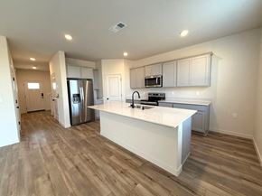 Merced house for rent - A kitchen with a white countertop and wooden flooring.