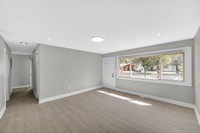 Gary house for rent - A spacious room with a large window and a view of the city.