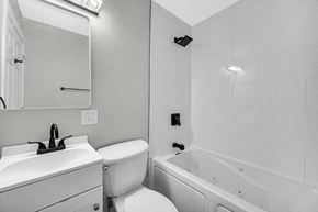 Gary house for rent - A white bathroom with a toilet, sink, and bathtub.