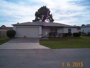 Homosassa house for rent - A house with a driveway and a tree in front of it.