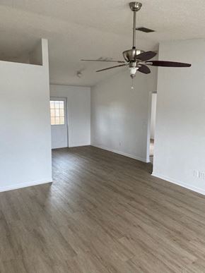 Homosassa house for rent - A room with a ceiling fan and light fixture.