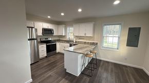 Pocomoke City house for rent - A kitchen with a refrigerator, microwave, oven, and cabinets.